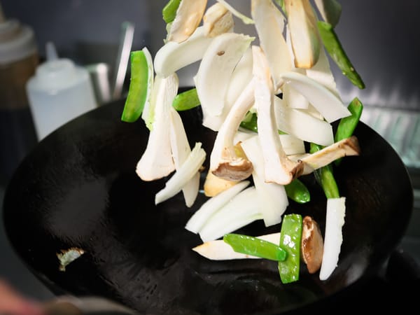 Gemüse wird im Wok geschwenkt
